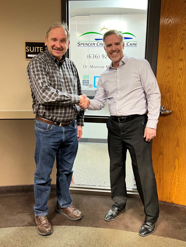 Handshake in front of Spencer Creek Dental Care office after successful dental practice sale